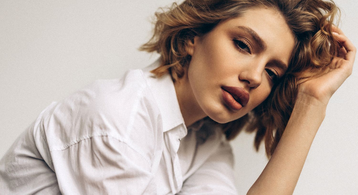 Woman with wavy hair in a white shirt.