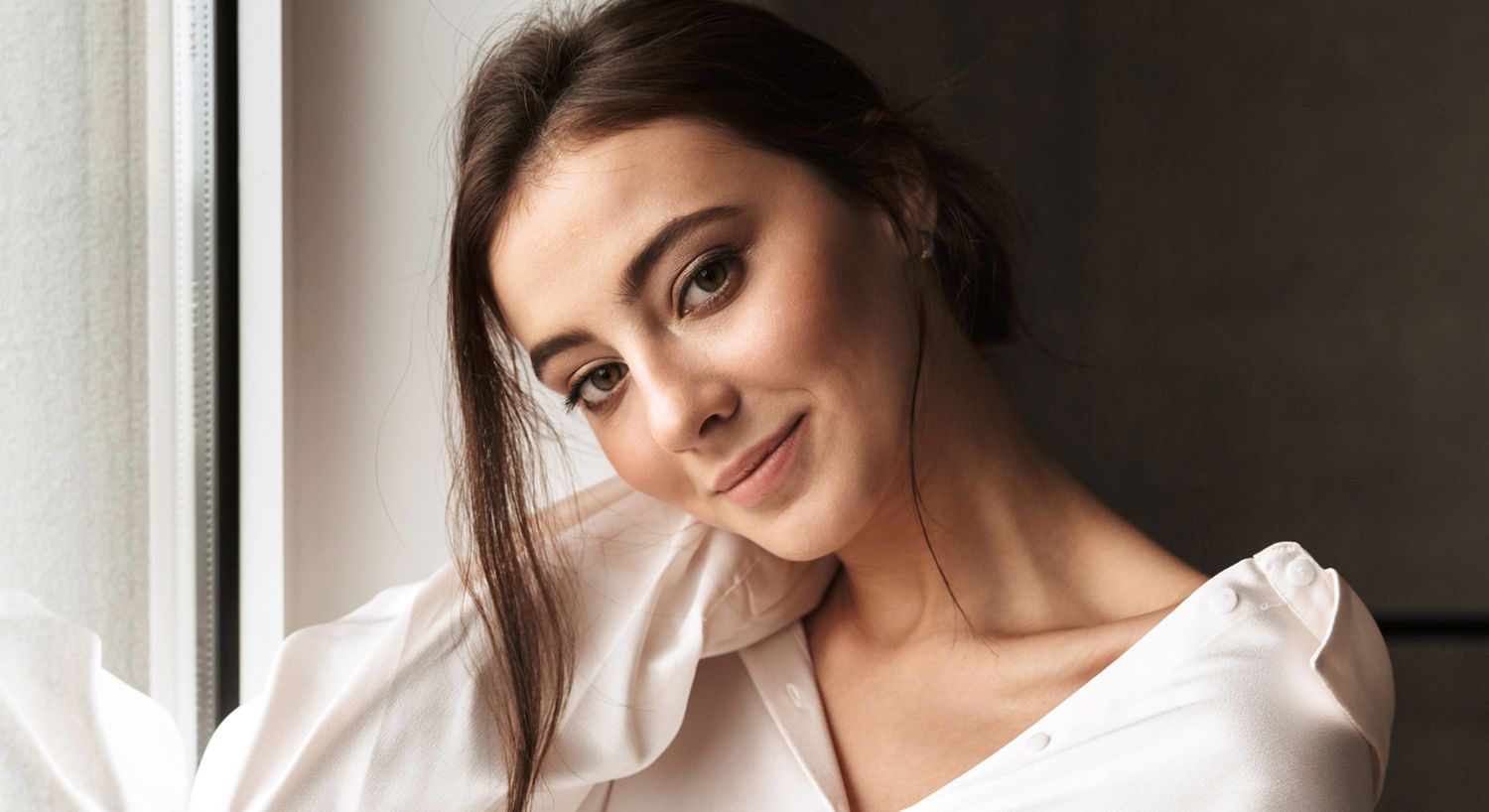 Smiling woman in a soft white blouse.